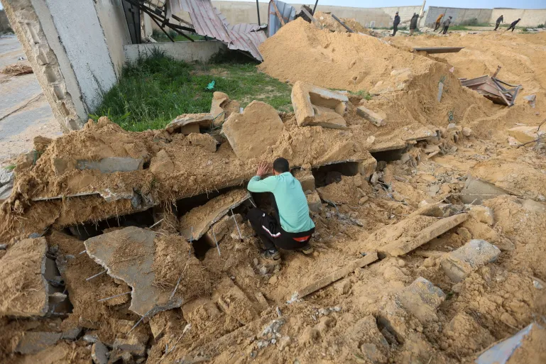 Un jeune Palestinien inspecte l'une des tombes détruites par l'occupation israélienne lors d'un raid aérien