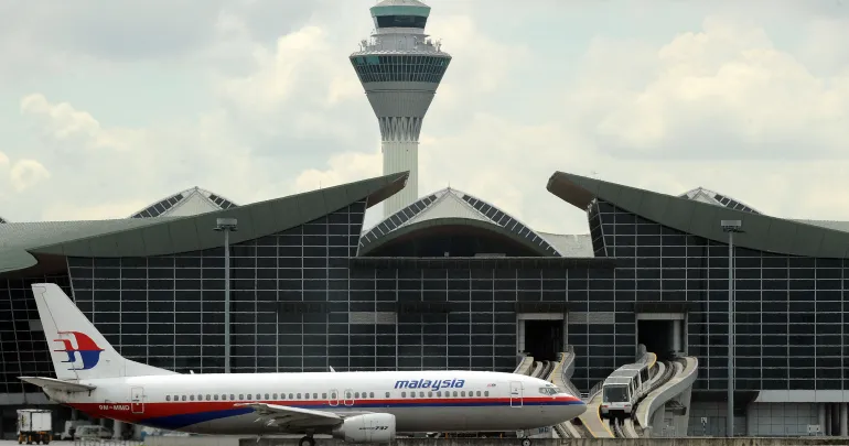 Un avion de Malaysia Airlines décolle alors qu'un aérotrain entre dans le terminal international de l'aéroport international de Kuala Lumpur à Sepang en août 2010. (AFP)