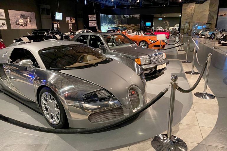 Visiteurs observant l'évolution des voitures exposées au Musée royal des voitures