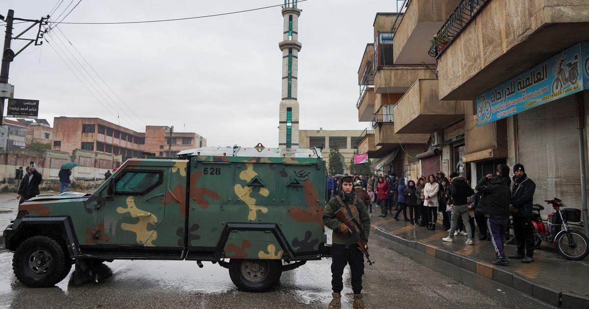 Foule alaouite brandissant des drapeaux
