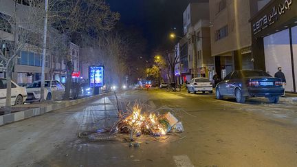 Des débris enflammés sur une route lors de troubles en Iran