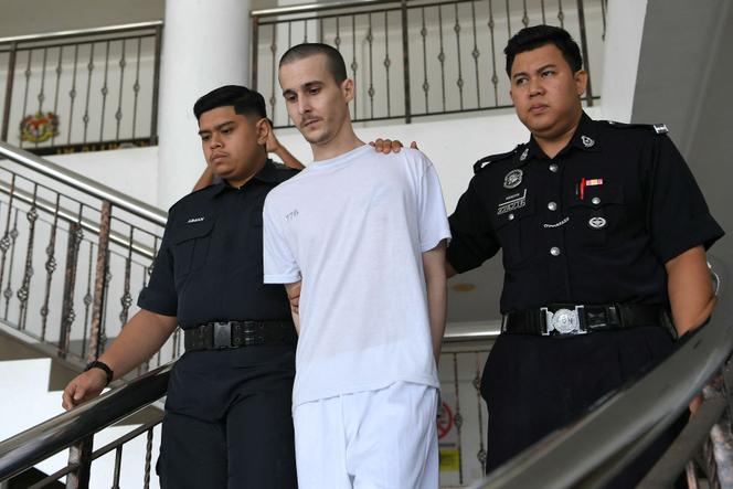 Tom Félix escorté par des officiers de la police royale malaisienne au tribunal d’Alor Setar