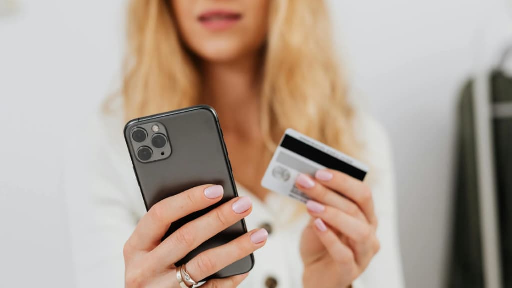 Illustration d'une femme utilisant un smartphone et une carte bancaire