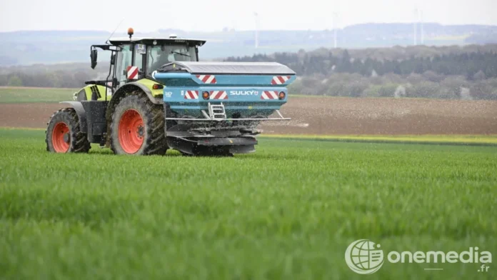 Agriculteur procédant à un épandage centrifuge de nitrate d'ammonium dans un champ