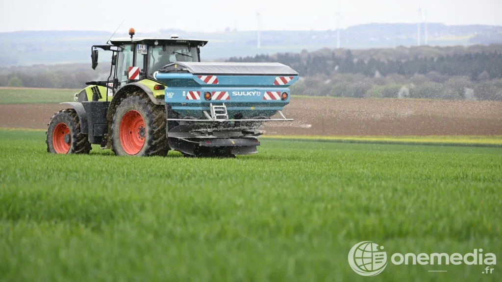 Agriculteur procédant à un épandage centrifuge de nitrate d'ammonium dans un champ