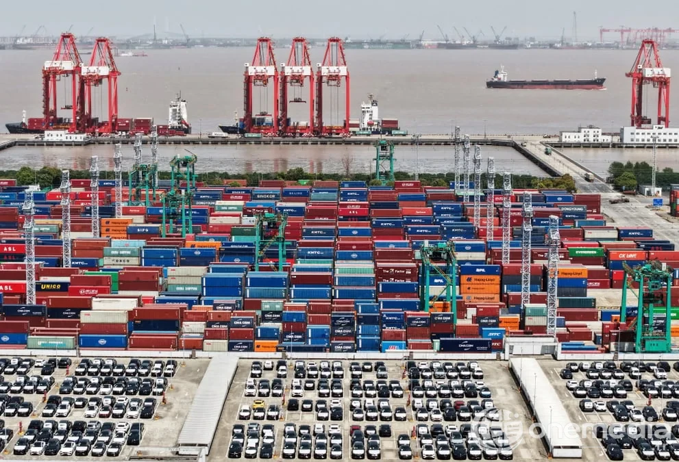 Vue aérienne d'un port d'exportation : véhicules électriques et conteneurs empilés, illustrant la concurrence commerciale entre l'Europe et la Chine
