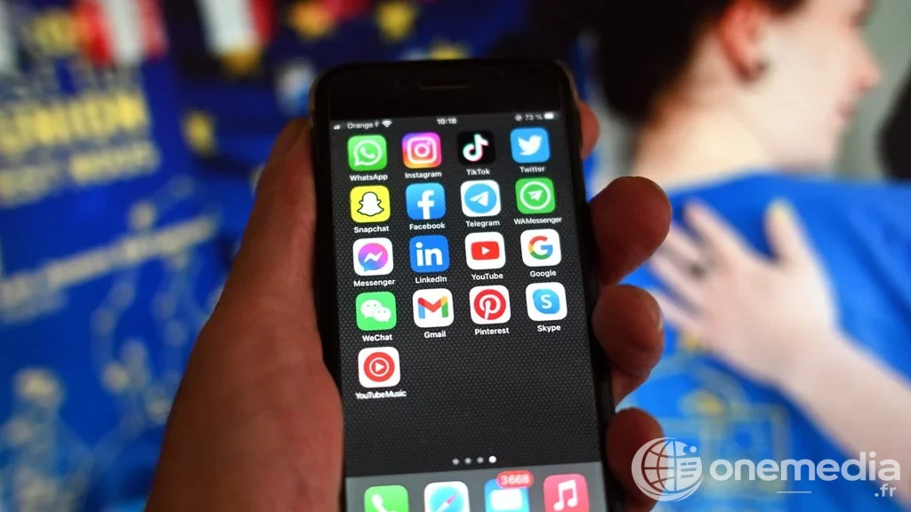Smartphone avec applications de réseaux sociaux et drapeau européen illustrant la loi française