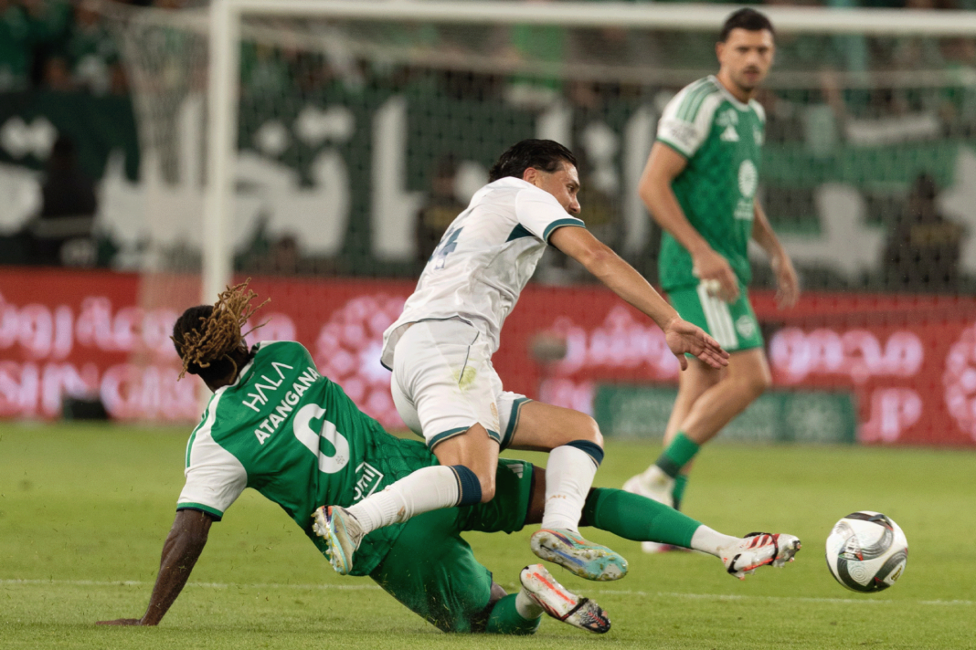 Duel entre joueurs en vert et en blanc lors d’un match du championnat saoudien.