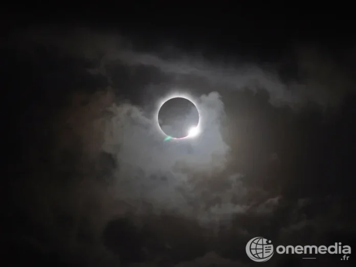 Une éclipse totale de Soleil observée à travers des nuages