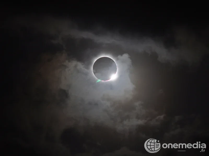 Une éclipse totale de Soleil observée à travers des nuages