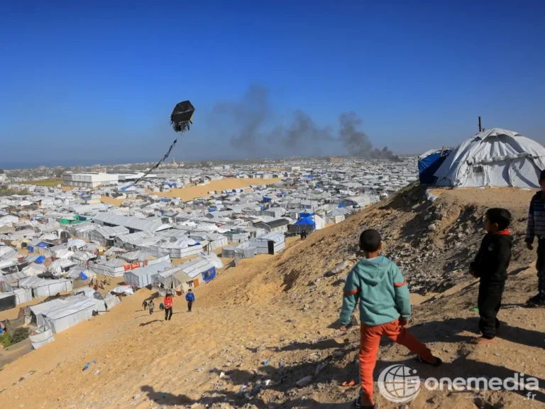 Un enfant fait voler un cerf-volant à Gaza devant des abris de déplacés
