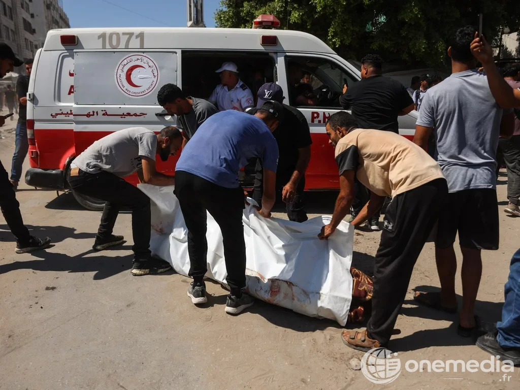 Des Palestiniens transportent un corps près d’une ambulance du Croissant-Rouge palestinien à Gaza.