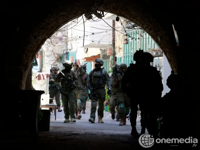 Des soldats armés sous une arche dans une ruelle de Cisjordanie