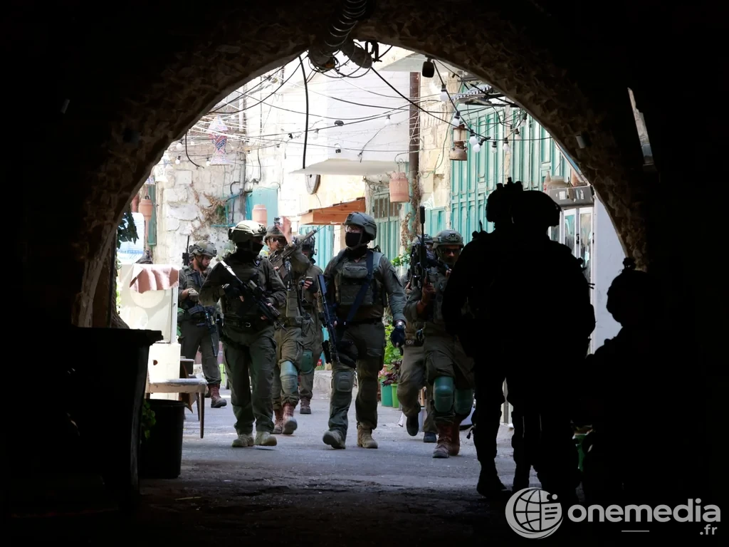 Des soldats armés sous une arche dans une ruelle de Cisjordanie