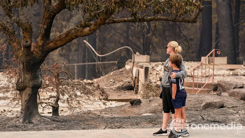 Une femme et un enfant devant les débris d'une habitation incendiée à Spokane.