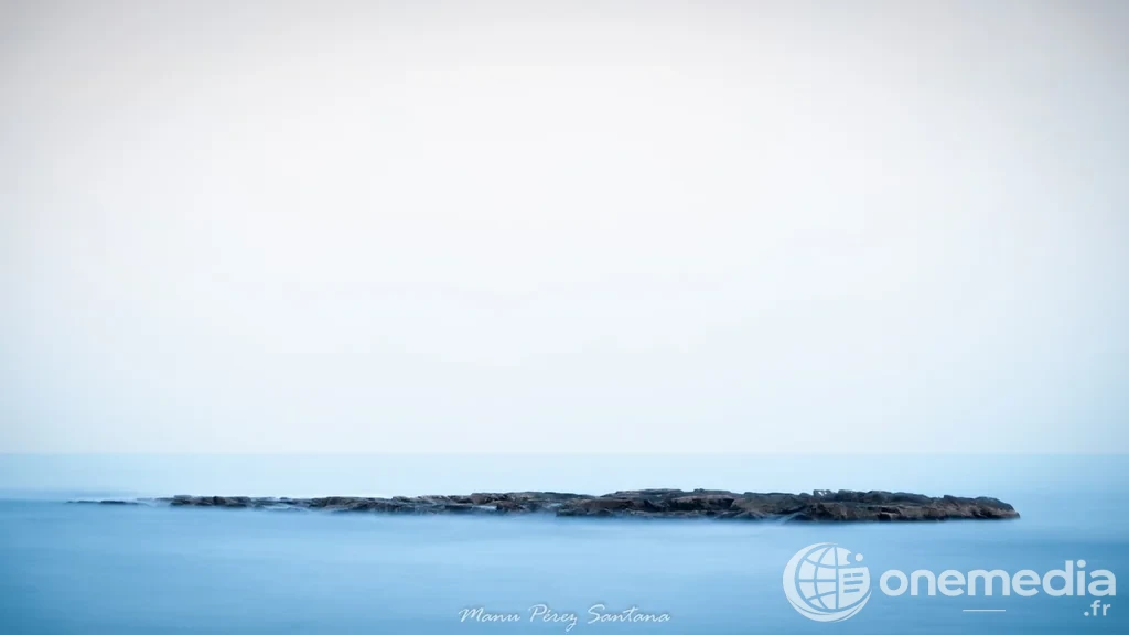 Mer calme autour d’un îlot rocheux