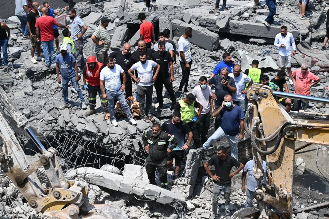 Habitants et secouristes au milieu des décombres d’un bâtiment détruit dans le sud du Liban.