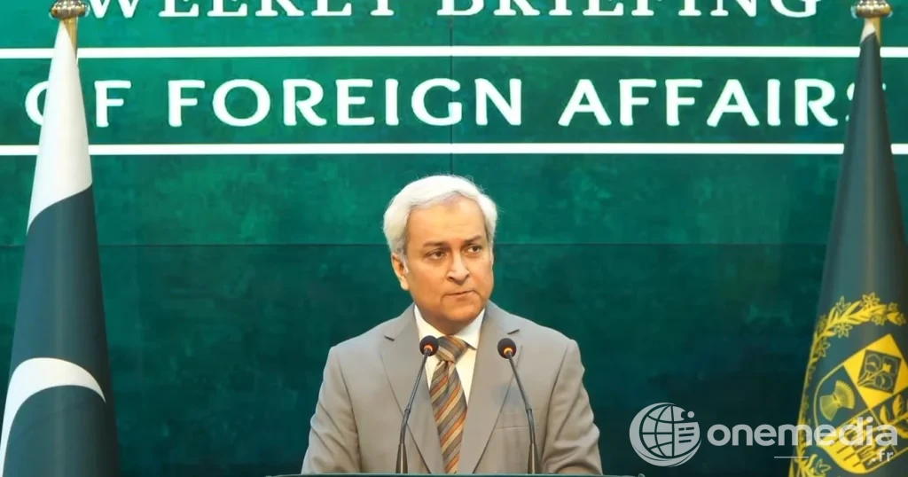 Un homme en costume s’exprime devant deux micros, entre un drapeau pakistanais et un panneau du ministère des Affaires étrangères.