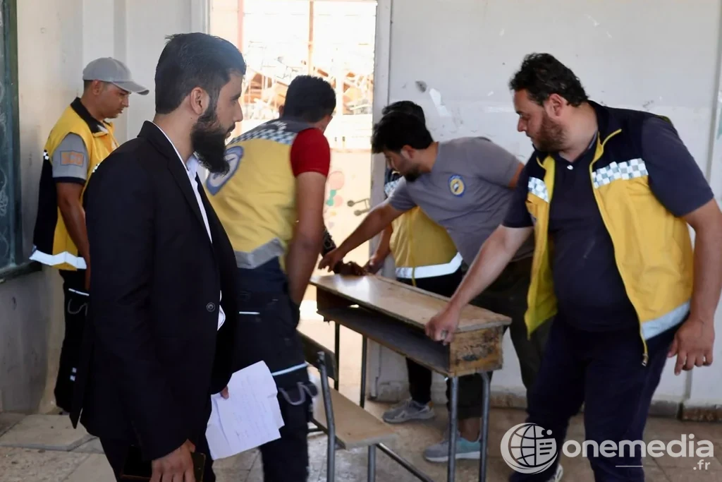 Des équipes préparent une salle de classe avec des tables dans le rural de Soueïda.