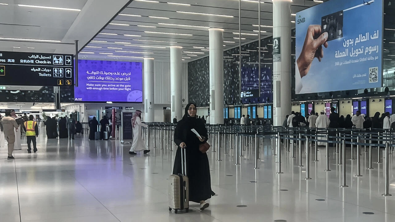 Une voyageuse avec sa valise dans le terminal des départs de l’aéroport King Khalid à Riyad.
