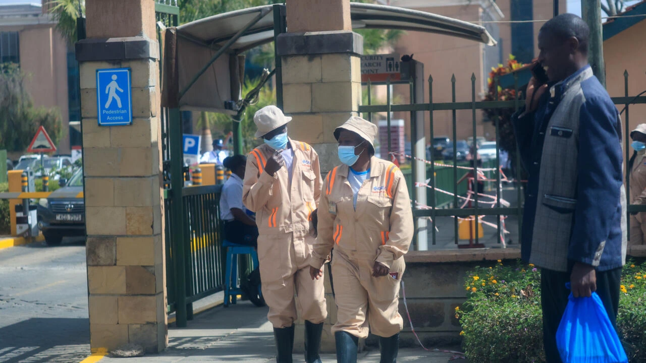 Des personnes portant un masque quittent le Nairobi Hospital.