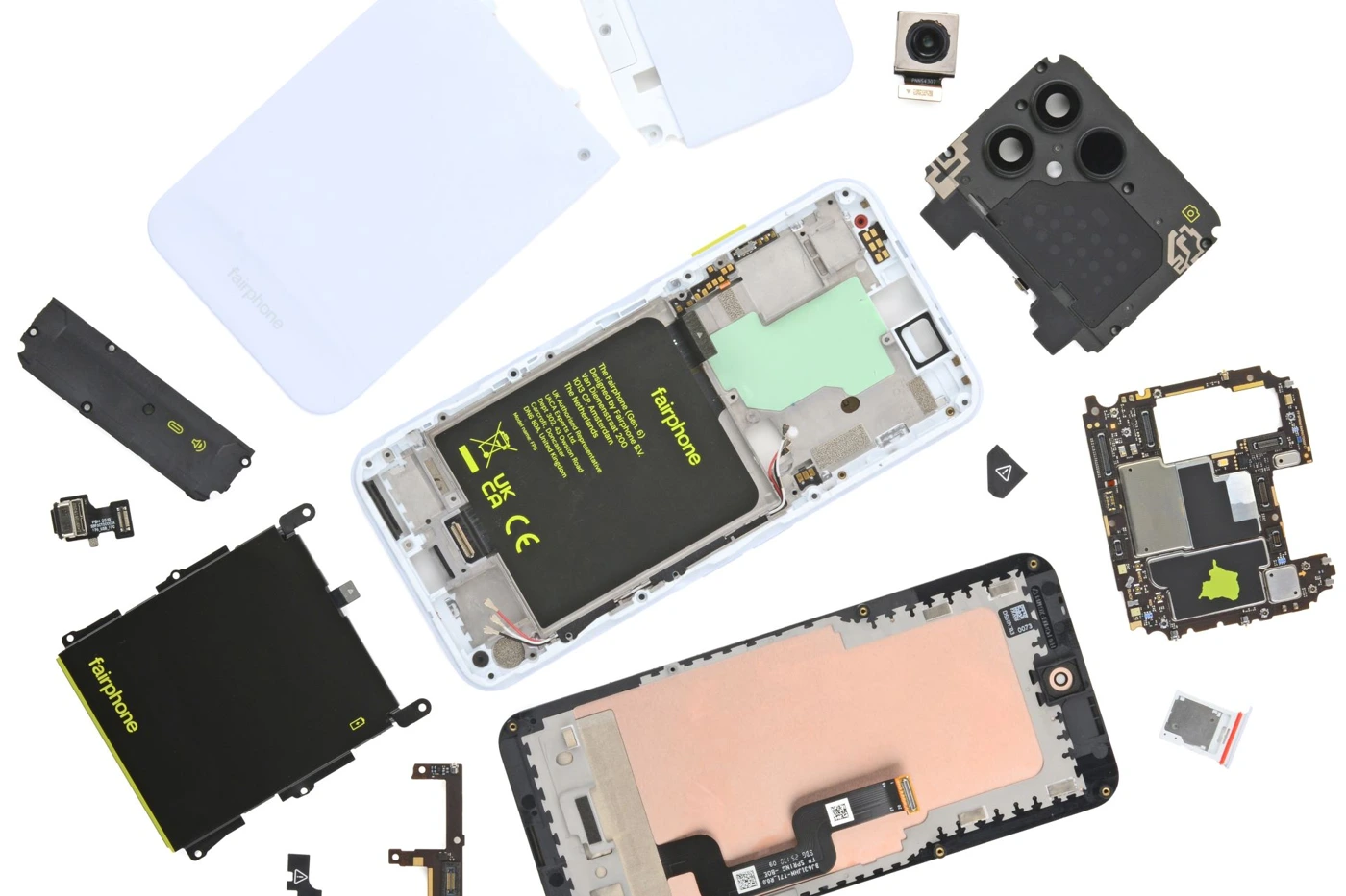 Pièces du Fairphone 6 disposées autour du châssis sur un fond blanc.
