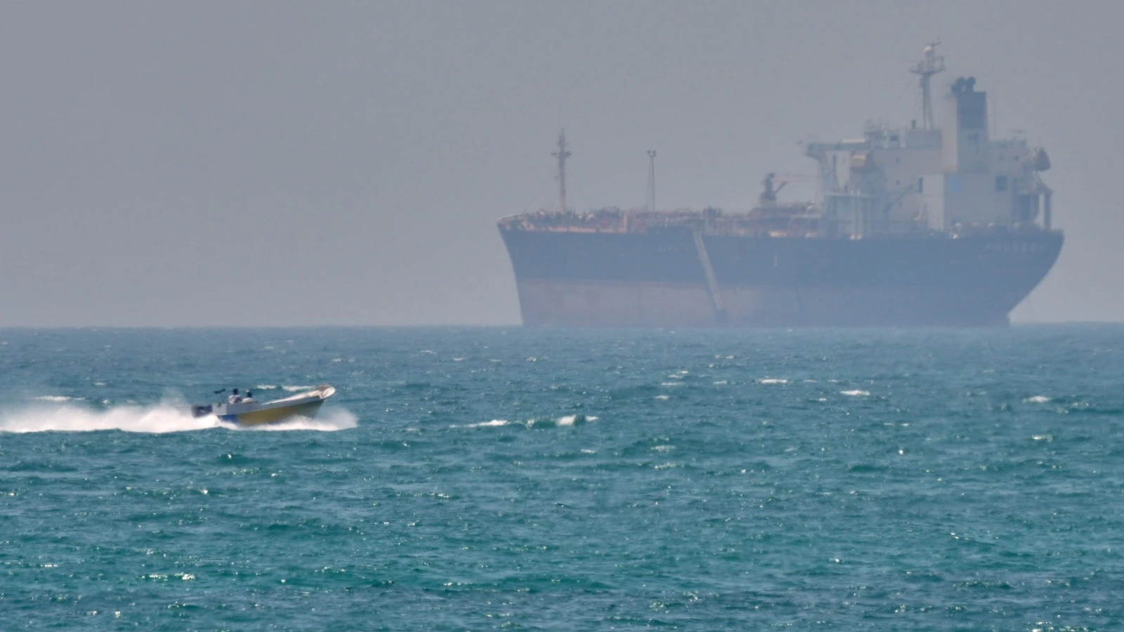 Une embarcation passe devant un pétrolier au mouillage dans le détroit d’Ormuz, au large de l’île iranienne de Qeshm.